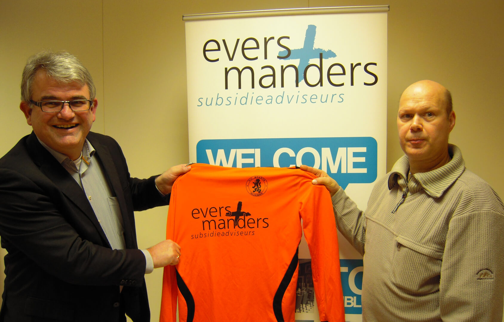 Dhr.Evers, links op de foto, ontvangt uit handen van Hans Lubbertsen, coördinator Recreatieteams VV Sparta NIJKERK, trots het nieuwe shirt.